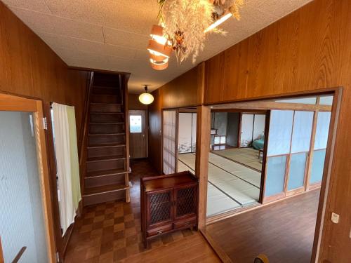 a hallway of a house with a staircase and a chandelier at ぶどう畑に囲まれた貸切宿 バーベキュー可能 白百合醸造から徒歩すぐ"Vineyard Vista" Vacation rental BBQ permitted short walk from Winery in Yamanashi