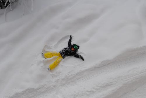 a person is snowboarding down a snow covered slope at Familien-Bauernhof Neumoar in Sankt Johann im Pongau