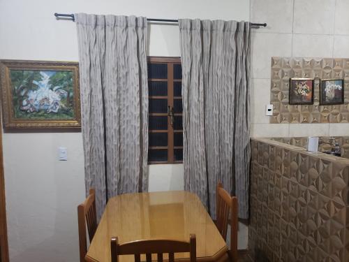 a table and chairs in a room with a window at Guest House in Uberlândia