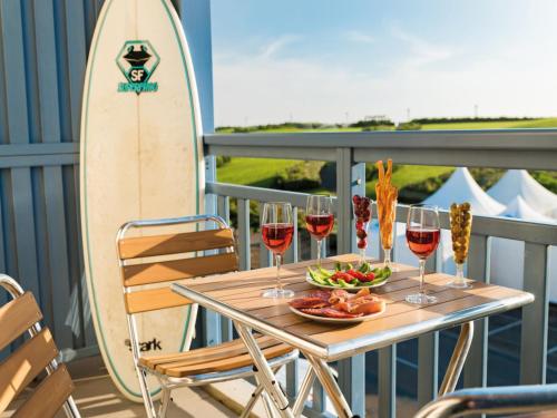 - une table avec des verres de vin et une planche de surf dans l'établissement Apartment in Biscarrosse by the Beach, à Biscarrosse