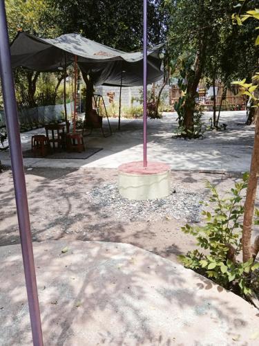 an umbrella in a park with a table and chairs at JUNGLE GYM LA UNION Prana fan kubo 2 pax in Rimus