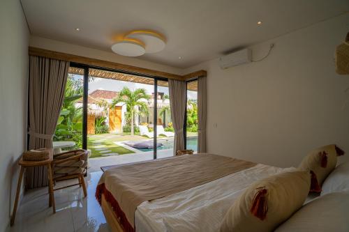 een slaapkamer met een groot bed en een groot raam bij NEW! Tropical Palms Villa - 4BR Villa in Kerobokan in Kerobokan