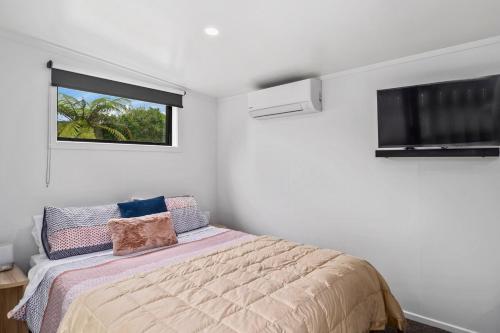 a bedroom with a bed and a window at Cozy cabin near adventure spots! in Rotorua