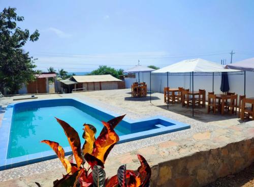 Blick auf einen Pool mit einem Tisch und Stühlen in der Unterkunft CASA de PLAYA con PISCINA FRENTE al MAR in Bocapán