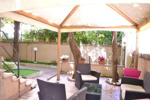 eine Terrasse mit Stühlen und einem weißen Sonnenschirm in der Unterkunft Tiburtina House in Rom
