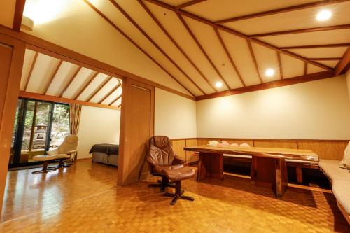 a living room with a desk and a bed at Ginsuisou Choraku in Kobe