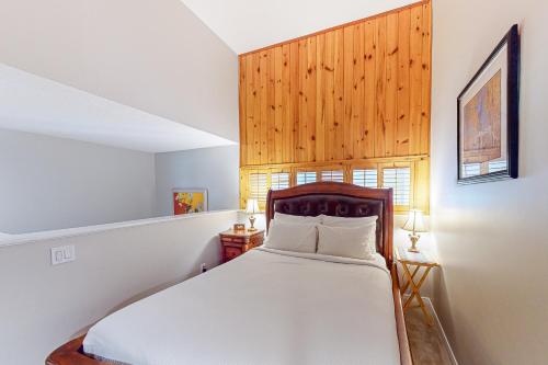 een slaapkamer met een wit bed met een houten hoofdeinde bij Wintergreen 122 in Blue Mountains