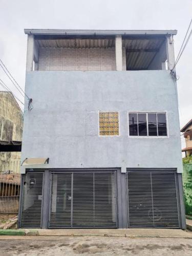 a building with two garage doors and two windows at Casa com Garagem in Guarulhos