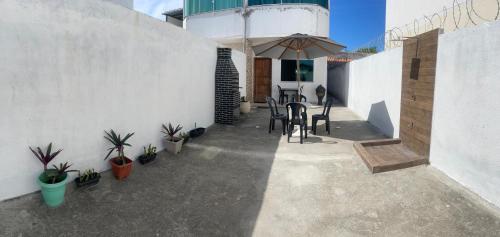 カボ・フリオにあるCasa Duplex 2 quartos com amplo quintalのテーブルと椅子と傘のあるパティオ