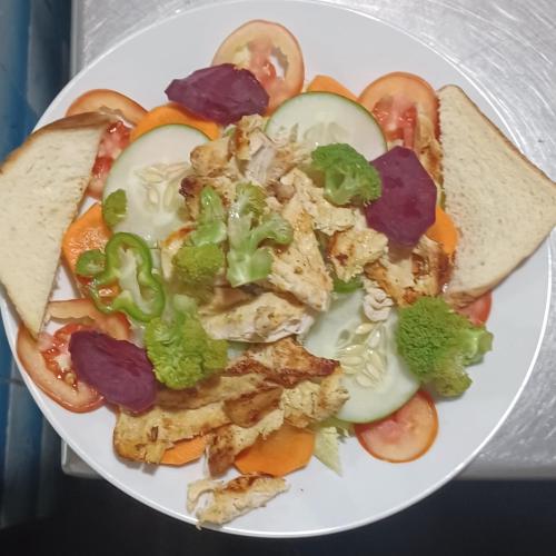 a white plate of food with vegetables and bread at Eco lodge finca magdalena in Altagracia