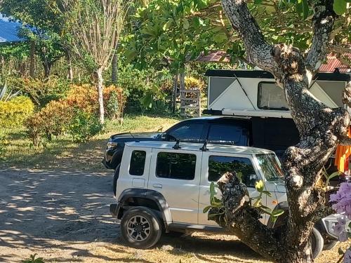a white jeep parked next to a tree at Eco lodge finca magdalena in Altagracia