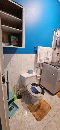 a bathroom with a toilet and a blue wall at Livi's Hide-Away! in Spanish Town