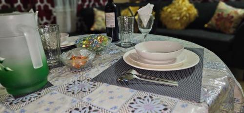 a table with a table cloth with a bowl and a plate at Livi's Hide-Away! in Spanish Town
