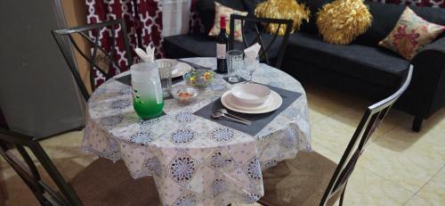 a table with a table cloth on it with wine bottles at Livi's Hide-Away! in Spanish Town