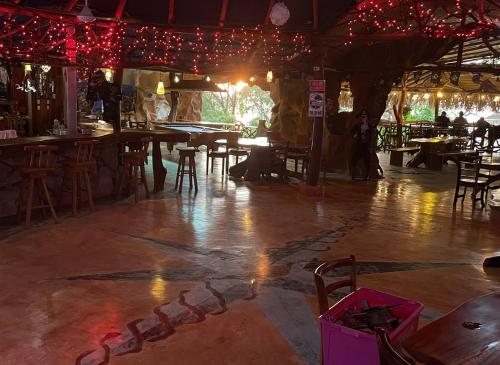 a room with tables and chairs and red lights at La Perla Negra Eco Pirate Resort in Puntarenas