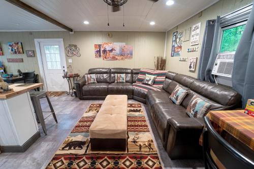 a living room with a leather couch and a table at Roscoe Cottage Pet Friendly in Roscoe