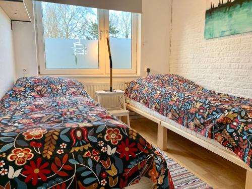a bedroom with two beds and a window at Bungalow in Sint Maartenszee near Beach in Sint Maartenszee