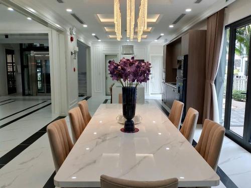 a dining room with a table with purple flowers on it at Family Villa - Phu Quoc Island in Phu Quoc