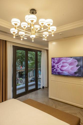 a bedroom with a large television and a chandelier at Family Villa - Phu Quoc Island in Phu Quoc