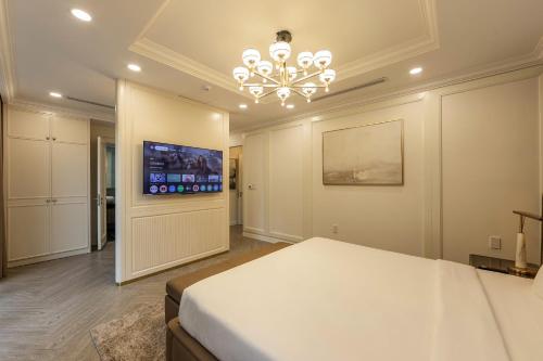 a bedroom with a large bed and a chandelier at Family Villa - Phu Quoc Island in Phu Quoc