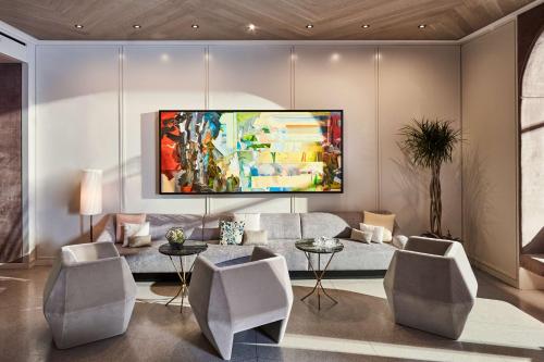 a living room with a couch and a tv on a wall at Hotel Seville NoMad - The Unbound Collection by Hyatt in New York