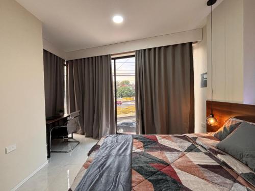 a bedroom with a bed and a desk and a window at Apartment in the heart of SA in Santa Ana