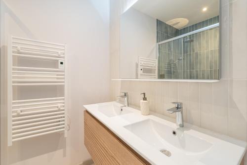 a white bathroom with a sink and a mirror at Suite haut de gamme - Appartement vue sur mer - Boulogne Sur Mer - Nausicaa in Boulogne-sur-Mer