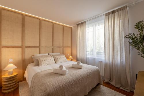 a bedroom with a large bed with two towels on it at Suite haut de gamme - Appartement vue sur mer - Boulogne Sur Mer - Nausicaa in Boulogne-sur-Mer