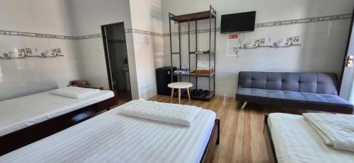 a room with two beds and a blue couch at Mobile Home Ho Tram Pristine Beach in Thuận Biên
