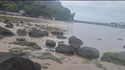 a group of rocks on the shore of a beach at Casa na praia com 2 quartos in Itanhaém
