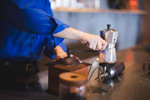 a person is using a blender on a counter at TheMana Village in Tosashimizu
