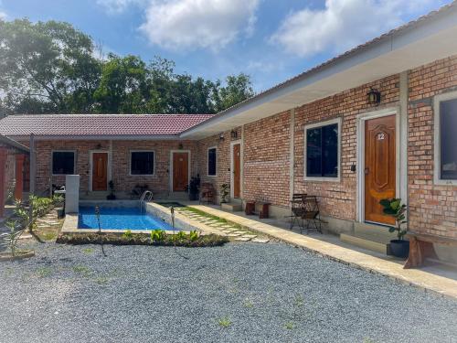 a brick house with a swimming pool in front of it at WIWI Village in Kemasik