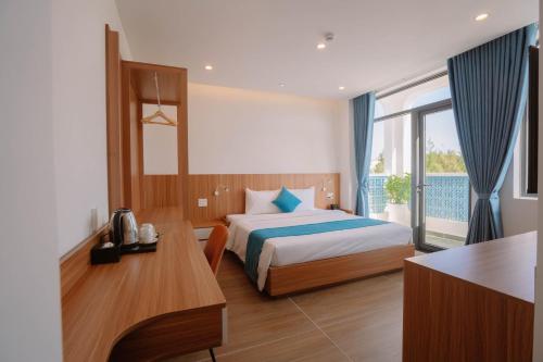 a hotel room with a bed and a desk and a window at Yen Hotel in Tuy Hoa