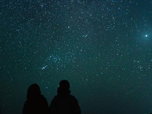 a group of people standing under a starry sky at TheMana Village in Tosashimizu