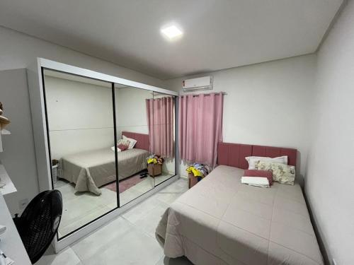 a bedroom with two beds and a mirror at Casa da Fran in Petrolina