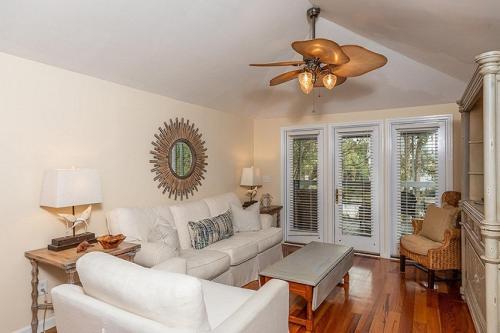 a living room with a white couch and a ceiling fan at Sandpiper Court 14 by Wild Dunes, with Amenities in Isle of Palms