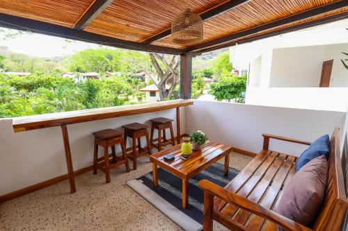 a balcony with a table and chairs and a bar at Cozy home near the beach in Playa Hermosa in Playa Hermosa