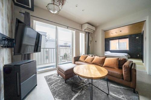 a living room with a couch and a tv at Taketo Stay Kotoni 302 in Sapporo