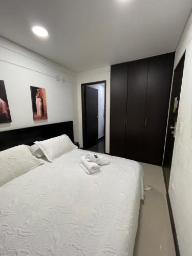 a bedroom with a white bed with two towels on it at Casa Hotel Spa Carolina in Carolina del Principe