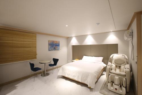 a bedroom with a bed and a table and chairs at Hotel rein in Gyeongju