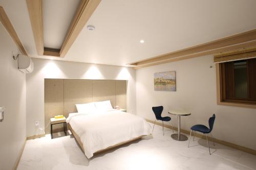 a bedroom with a bed and two chairs and a table at Hotel rein in Gyeongju