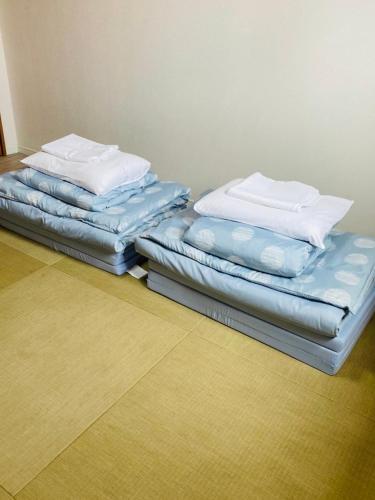 two mattresses stacked on top of each other in a room at ヴィラパーム in Miyako-jima