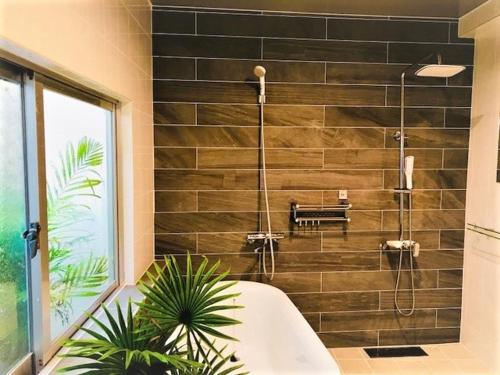 a bathroom with a shower and a bath tub at ヴィラパーム in Miyako-jima
