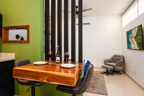 a dining room with a wooden table with two glasses of wine at 2 Nature Villas with Pool in Santa Cruz