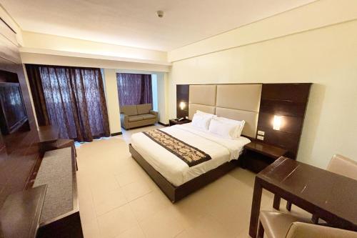 a large hotel room with a bed and a chair at The Muse Hotel Boracay in Boracay