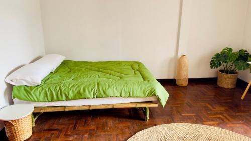 a bed with a green comforter in a room at Creative Bangkok Balcony in Sathani Bang Khen