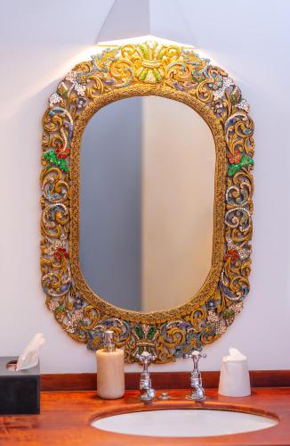 a bathroom sink with a gold mirror on the wall at Adigars Manor in Kandy