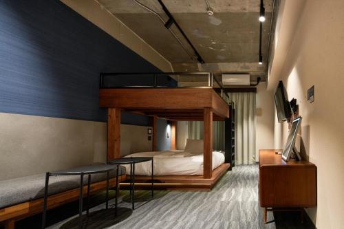 a bedroom with a bunk bed and a bed with stools at BbyC Hotel 那覇 レンタカー付ホテル in Naha