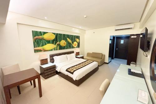 a bedroom with a bed and a couch and a table at The Muse Hotel Boracay in Boracay