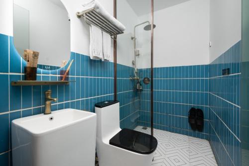 a bathroom with a toilet and a shower with blue tiles at LIA Hotel Shenzhen Convention and Exhibition Center in Shenzhen